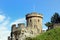 Tower and battlements of a medieval English castle on a grassy m