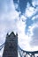 The Tower Bridge in London against a blue sky with puffy white clouds