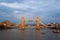 Tower bridge in London, United Kingdom. Bridge over Thames river on cloudy sky. Buildings on river banks with nice