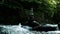 Tower or cairn stands on a cobblestone in a mountain river, slow motion