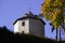 The tower of the castle behind the hedge against the blue autumn sky, the old building of stone, small Windows loopholes