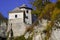 The tower of the castle behind the hedge against the blue autumn sky, the old building of stone, small Windows loopholes