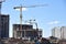 Tower crane and builders in action on blue sky background. Workers during formwork and pouring concrete through a Ñoncrete pump