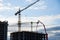 Tower crane and builders in action on blue sky background. Workers during formwork and pouring concrete through a Ñoncrete pump