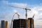 Tower crane and builders in action on blue sky background. Workers during formwork and pouring concrete through a Ñoncrete pump