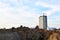 Tower crane constructing a new building at a construction site on the against blue sky.