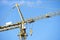 Tower crane high in blue sky close up of lifting hook