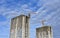 Tower cranes in action at construction site on blue sky background