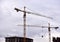 Tower cranes in action at construction site. Construction of skeleton of new modern residential buildings. Preparing to pour of