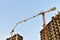 Tower cranes in action at construction site. Construction of skeleton of new modern residential buildings. Preparing to pour of