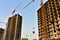 Tower cranes in action at construction site. Construction of skeleton of new modern residential buildings. Preparing to pour of