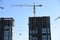 Tower cranes in action at construction site. Construction of skeleton of new modern residential buildings. Preparing to pour of