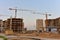 Tower cranes in action at construction site. Construction of skeleton of new modern residential buildings. Preparing to pour of