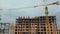 Tower cranes at high residential apartment buildings construction site. Real estate development