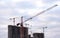 Tower cranes at large scale construction site against blue sky. Construction crane. Formwork solutions for reinforced construction