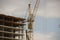 Tower cranes work during the construction of a multi-story building. New apartments for residents and premises for offices. Risky