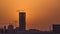 A tower in Doha timelapse, Qatar, under construction, silhouetted against the sunset.