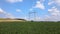 Tower with electric power lines for transfering high voltage electricity located in agricultural cornfield. Delivery of