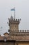 Tower with flag and bells over the state museum of San Marino in the fog