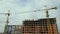 Tower lifting crane and high residential apartment building with monolithic frame under construction. Real estate