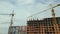 Tower lifting cranes at high residential apartment buildings construction site. Real estate development