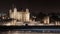 The Tower of London at night next to the River Thames - Light rails from passing boats