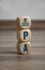 Tower made of cubes or dice with PA Personal Assistant on wooden background