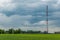 Tower of mobile communication and telecommunication in rural areas against the background of the cloudy sky