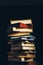 Tower Of Old Multi-colored Books On A Black Background. Concept Of Education And Knowledge