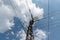 Tower with power wires against the blue sky with fluffy clouds