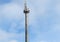 Tower with radar equipment, GSM communications antennas and transmitters against the beautiful blue sky with clouds