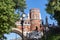 Tower of red brick, with white elements. Black lampposts. Arch bridge made of stone.