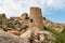 Tower ruins with Omani flag into the hills of the old village Misfat Al Abriyeen  Sultanate of Oman