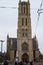 Tower of Saint Bavo Cathedral or Sint-Baafs Cathedral in Sint-Baafsplein square with the statue of Jan Frans Willems. Ghent,