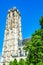 The tower of Saint Rumbold`s Cathedral beyound green tree leaves in Mechelen, Belgium