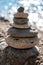 A tower of stones. Balanced pyramid of pebbles on the beach on a sunny day. Blue sea in the background. Selective focus