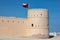 Tower of Sunaysilah fort in Sur featuring raised Omani flag