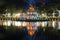 A tower of the Turtle against the background of the city embankment in a night landscape. Hanoi, Vietnam