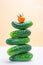 A tower of whole fresh cucumbers and tomato on a light neutral background.