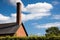 towering brick chimney in a rural landscape