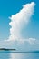Towering cloud rising from a storm from on a tropical shoreline in early morning