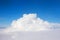 A towering cumulonimbus cloud among stratocumulus clouds as seen from an airplane