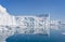 Towering great icebergs and their reflections in the Ilulissat Icefjord in Greenland