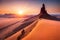 A towering sandstone spire in the desert with climbers ascending its challenging features, surrounded by arid beauty