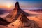 A towering sandstone spire in the desert with climbers ascending its challenging features, surrounded by arid beauty