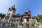 Towering statue of King Carol I overlooks the main entrance of Peles Castle