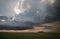 A towering supercell thunderstorm, or cumulonimbus cloud, moves over the prairie.