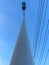 a towering white electricity pole and black wires on the right against the background of a bright blue sky