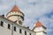 Towers of beautiful restored white castle with red tiles and blue sky in Czech Republic