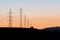 Towers of electricity over mountains at sunset